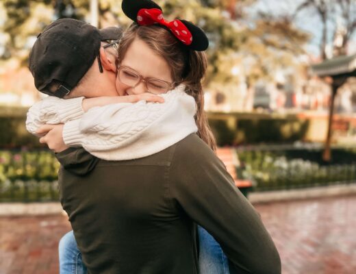 little girl in her dad's arms with Mickey Mouse ears on