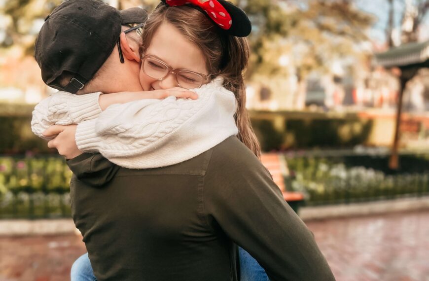 little girl in her dad's arms with Mickey Mouse ears on