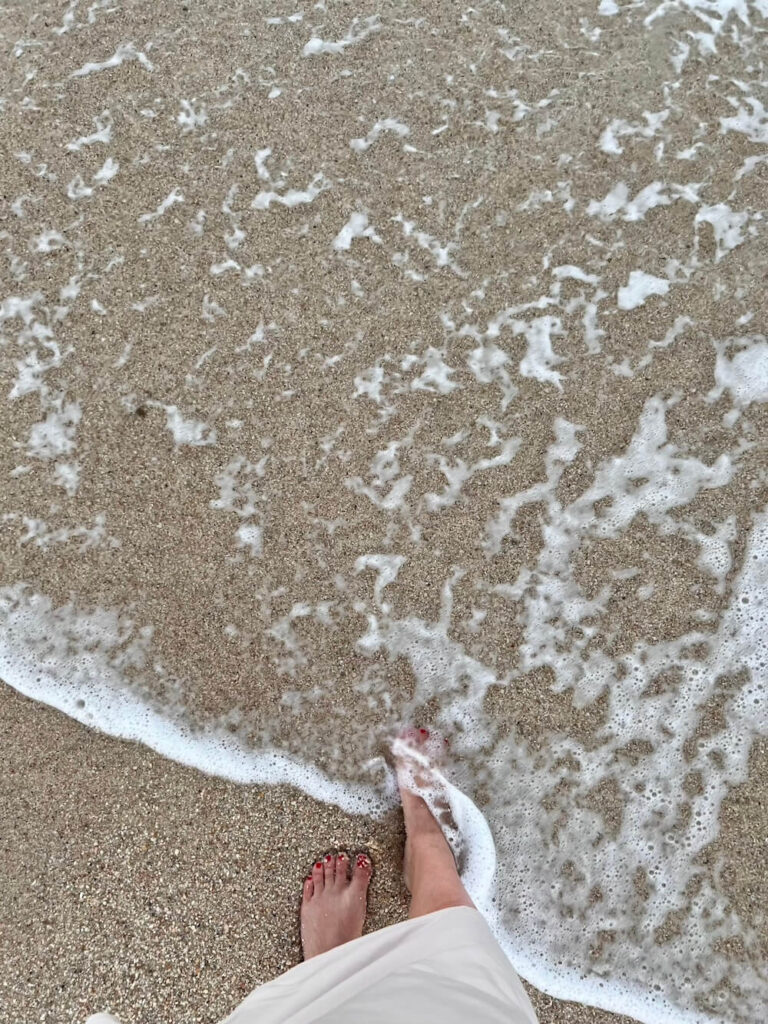 feet in sand and water in Cabo