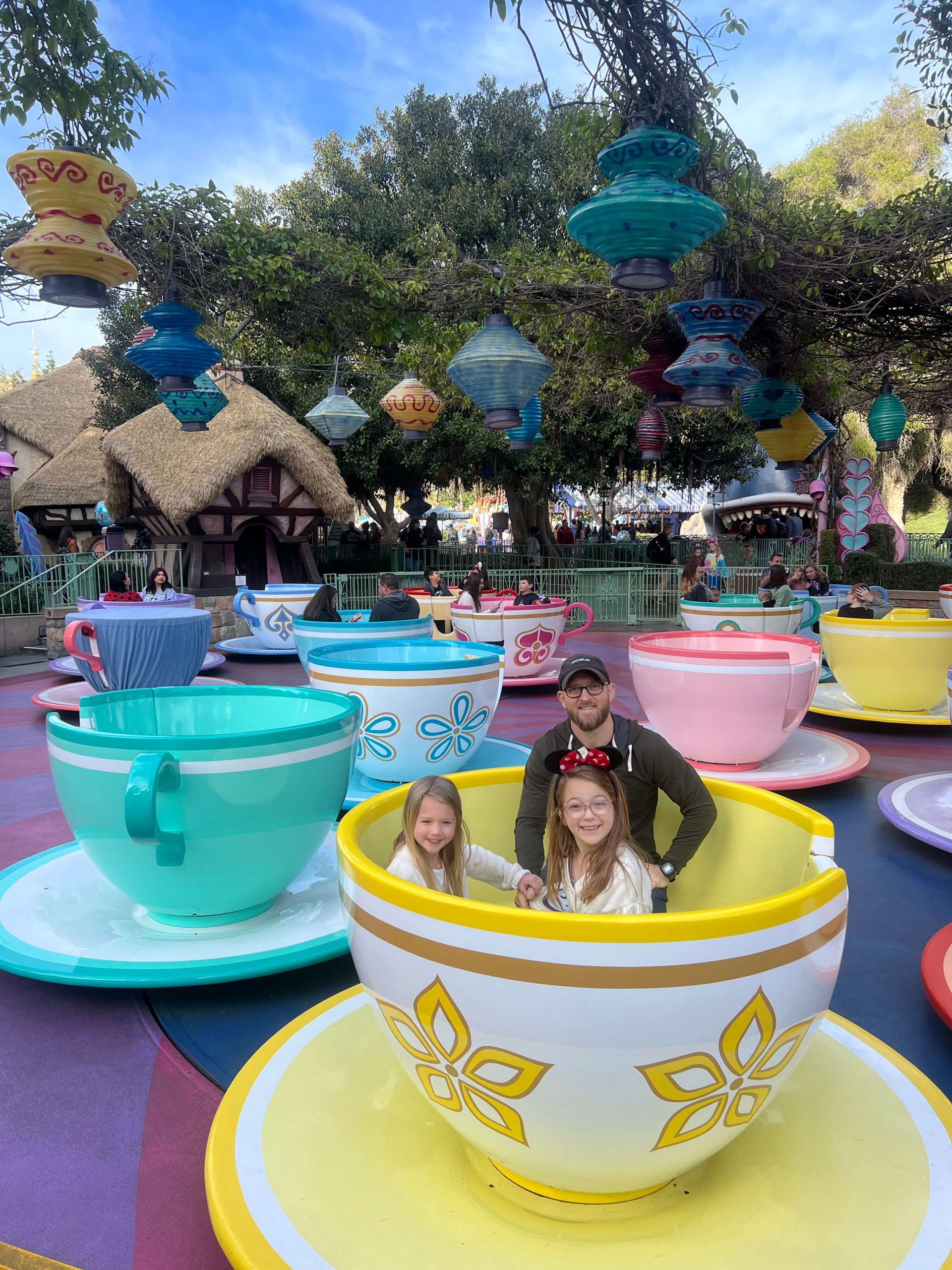 dad and 2 little girls in the teacups at Disneyland