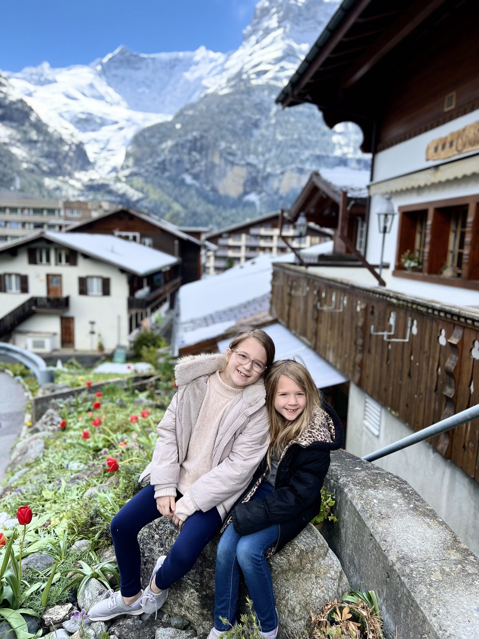 two little girls in front of swiss homes
